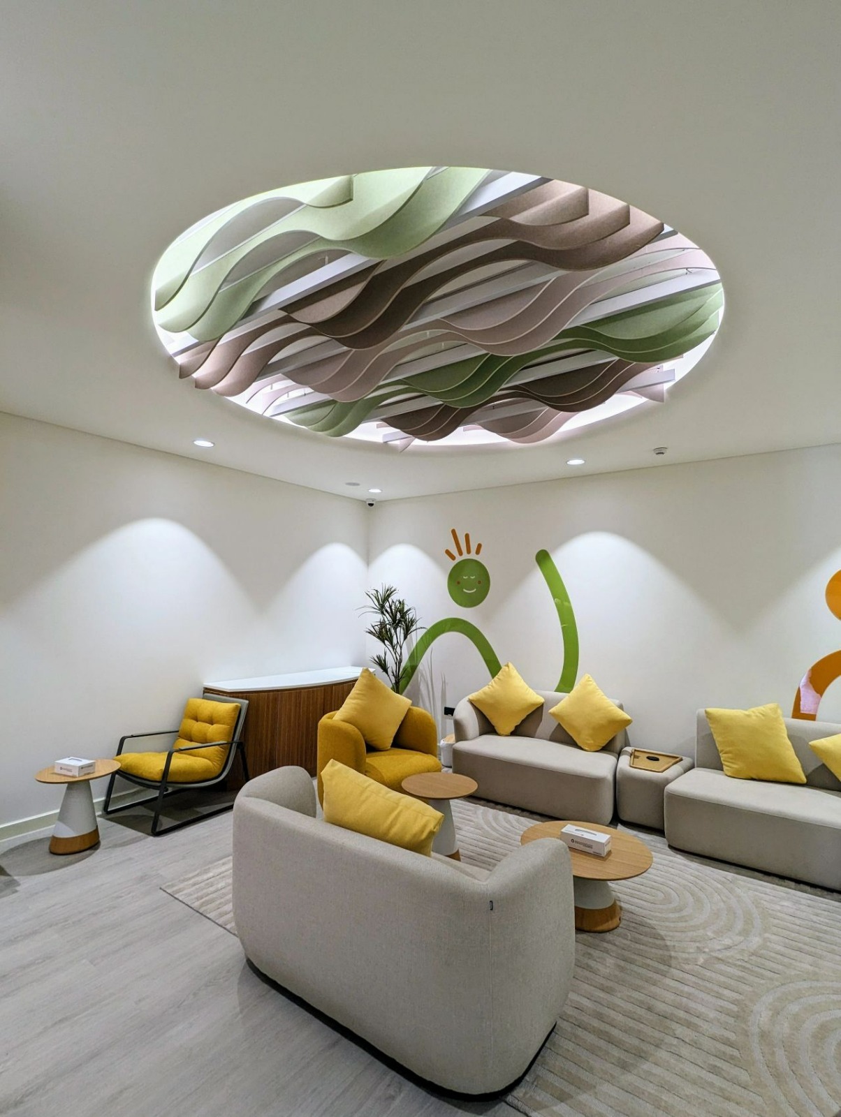 Circular acoustic ceiling clouds installed above a breakout seating area in a UAE corporate office